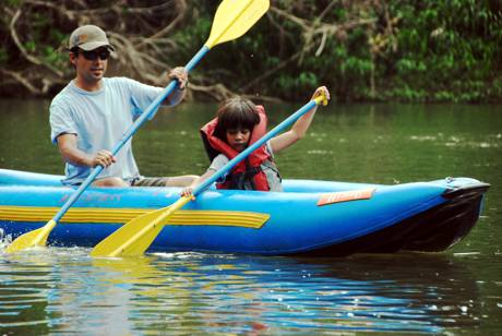 Dad anbd son paddling in the shallow river