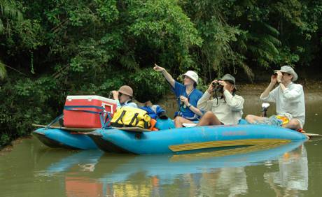 People and gear paddle down the river to the campsite