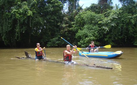 Serendipity guests riding log next to boats